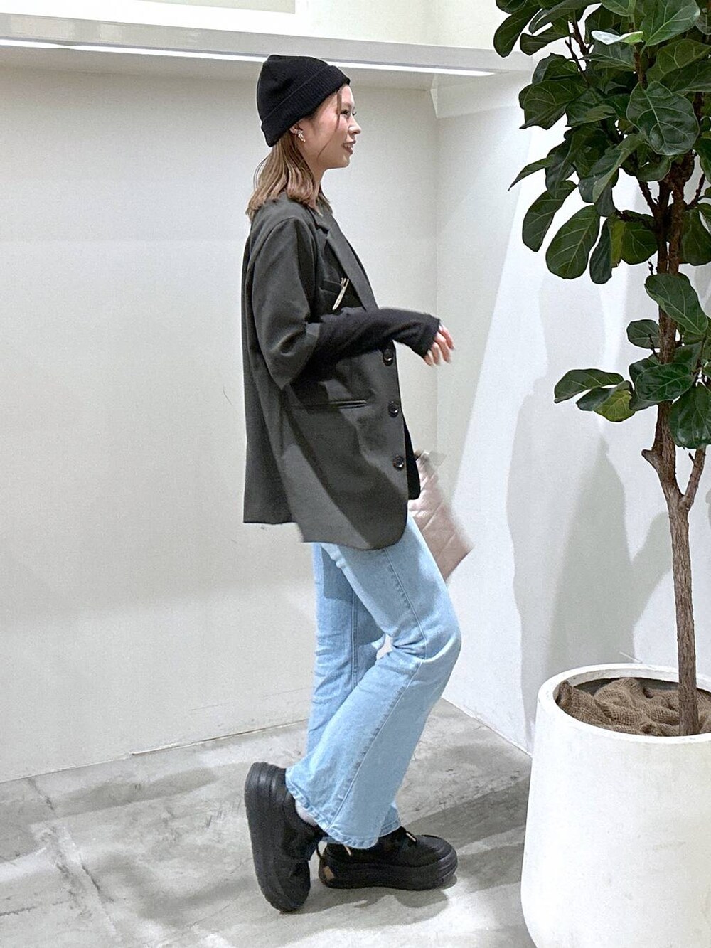 ブラック系のスニーカー、ブラック系のTシャツ/カットソー、ブルー系のデニムパンツを着用したレディースの春コーディネートの3枚目の写真