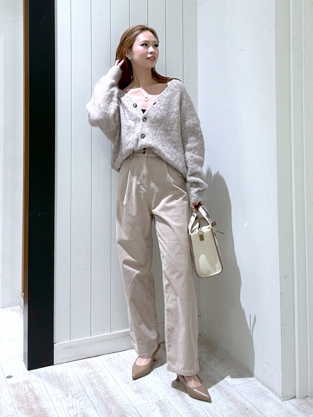ベージュ系のその他パンツ、ブラウン系のカーディガン/ボレロ、ベージュ系のトートバッグを着用したレディースの冬コーディネートの2枚目の写真