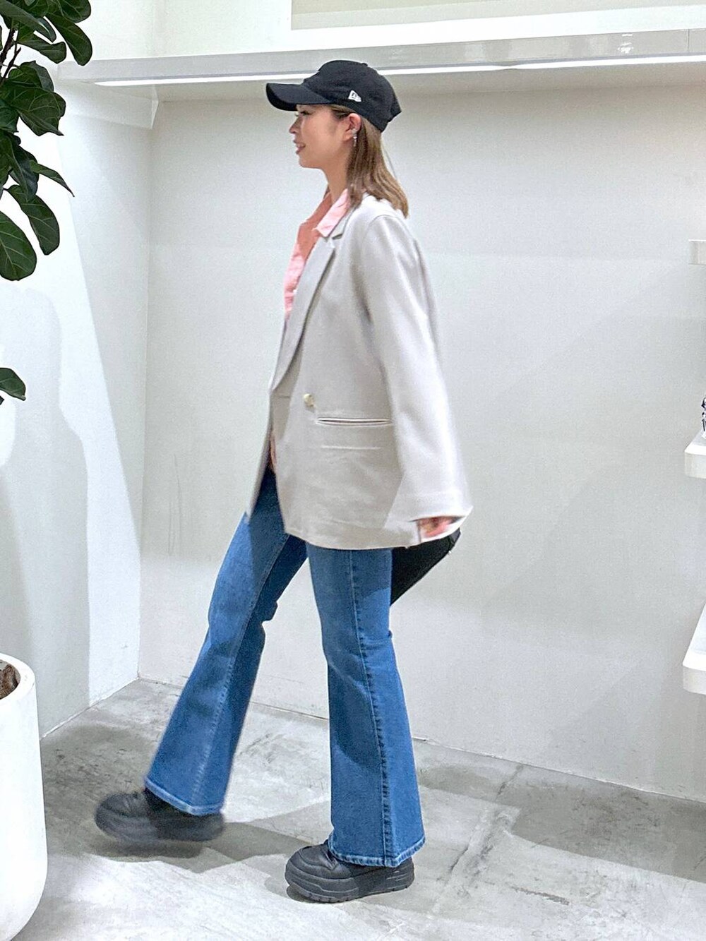 ブラック系のスニーカー、ピンク系のシャツ/ブラウス、ブラック系のショルダーバッグを着用したレディースの春コーディネートの4枚目の写真