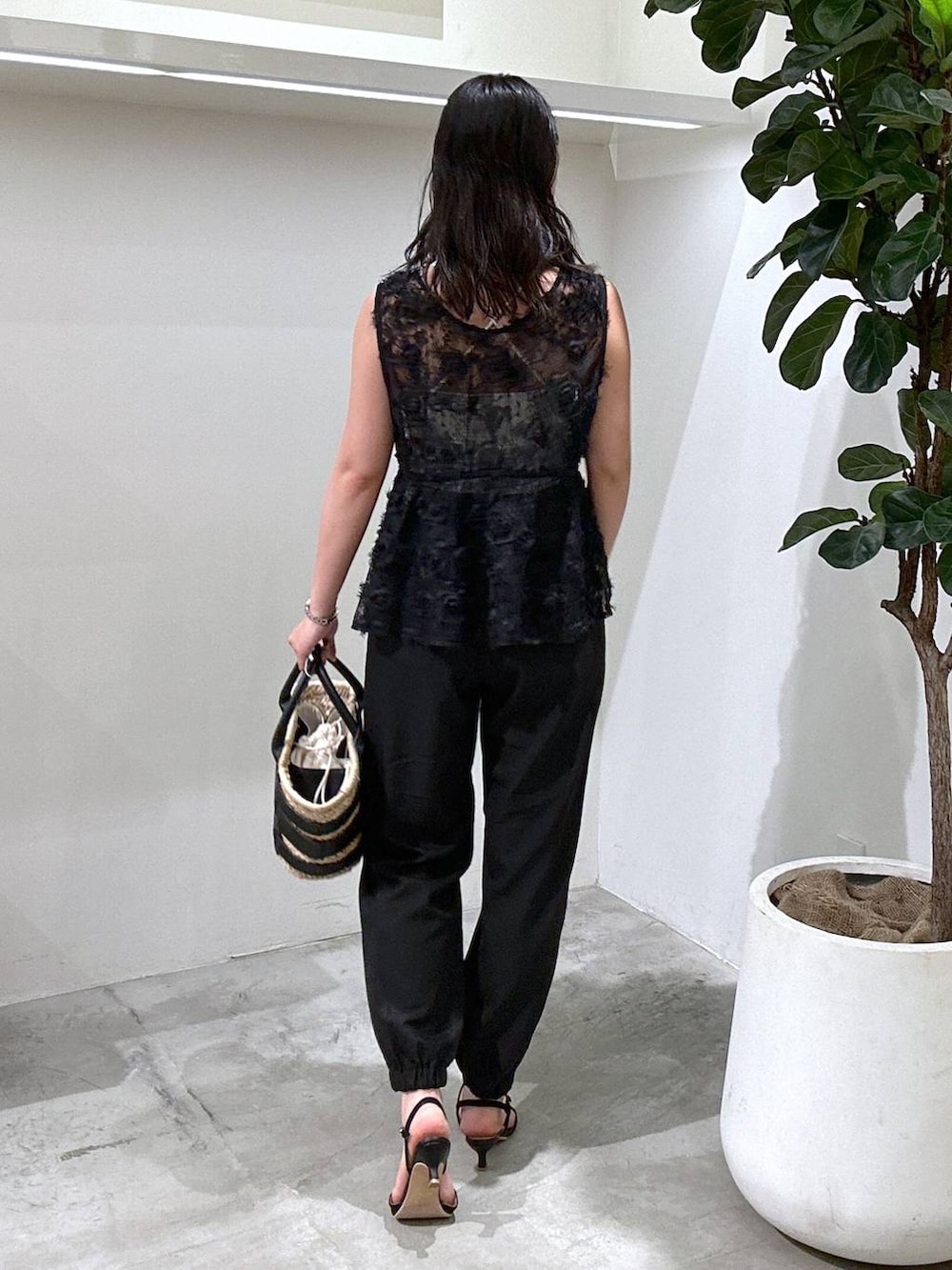 ブラック系のその他パンツ、ブラック系のかごバッグ、ブラック系のサンダルを着用したレディースの夏コーディネートの2枚目の写真