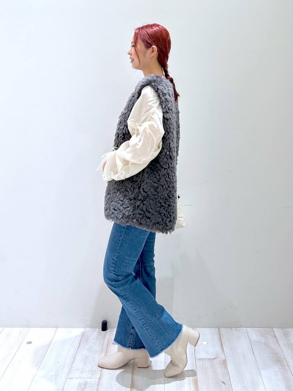 ベージュ系のショルダーバッグ、ホワイト系のシャツ/ブラウス、ブルー系のデニムパンツを着用したレディースの秋コーディネートの2枚目の写真