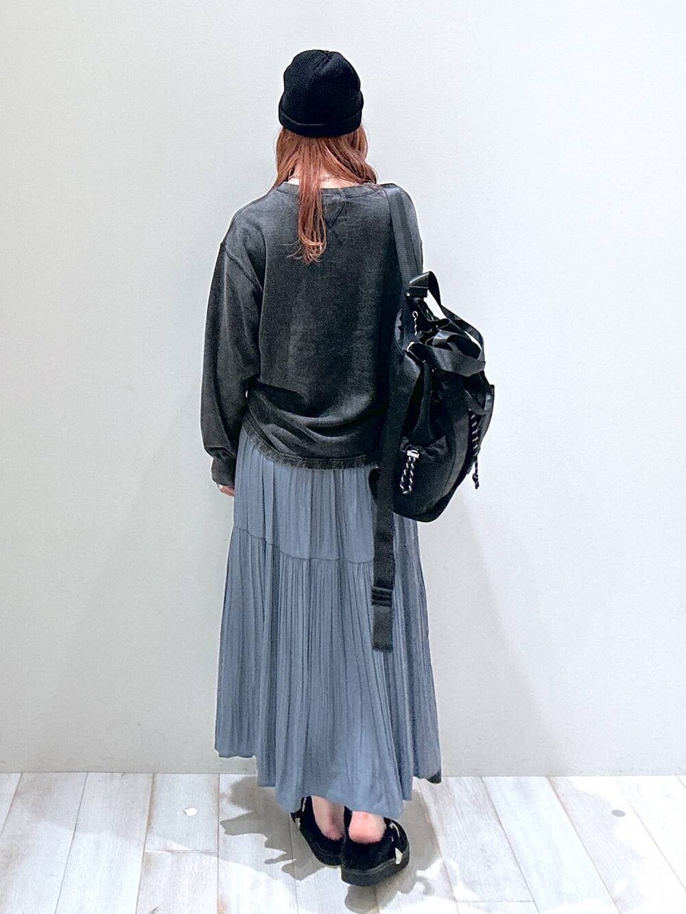 ブラック系のバックパック/リュック、グレー系のTシャツ/カットソー、ブルー系のスカートを着用したレディースの秋コーディネートの3枚目の写真