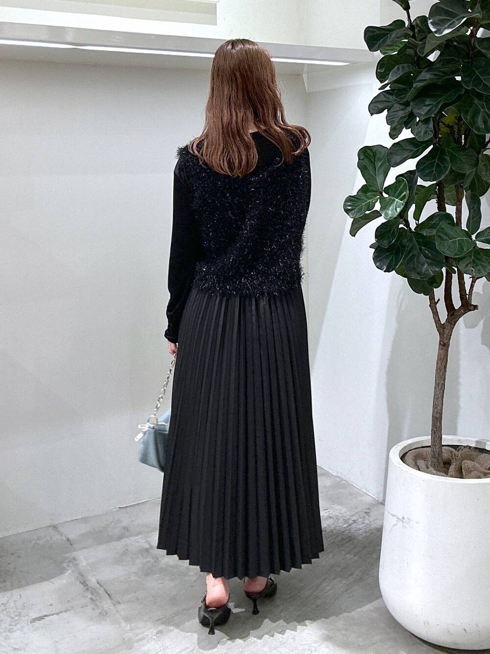 ブルー系のショルダーバッグ、ブラック系のスカート、ブラック系のパンプスを着用したレディースの秋コーディネートの3枚目の写真