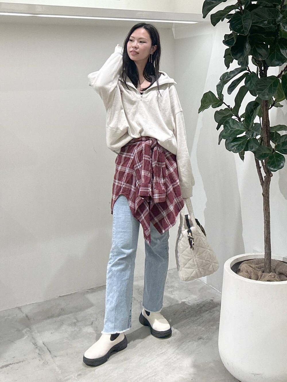 レッド系のシャツ/ブラウス、ブルー系のデニムパンツ、ホワイト系のブーツを着用したレディースの冬コーディネートの2枚目の写真