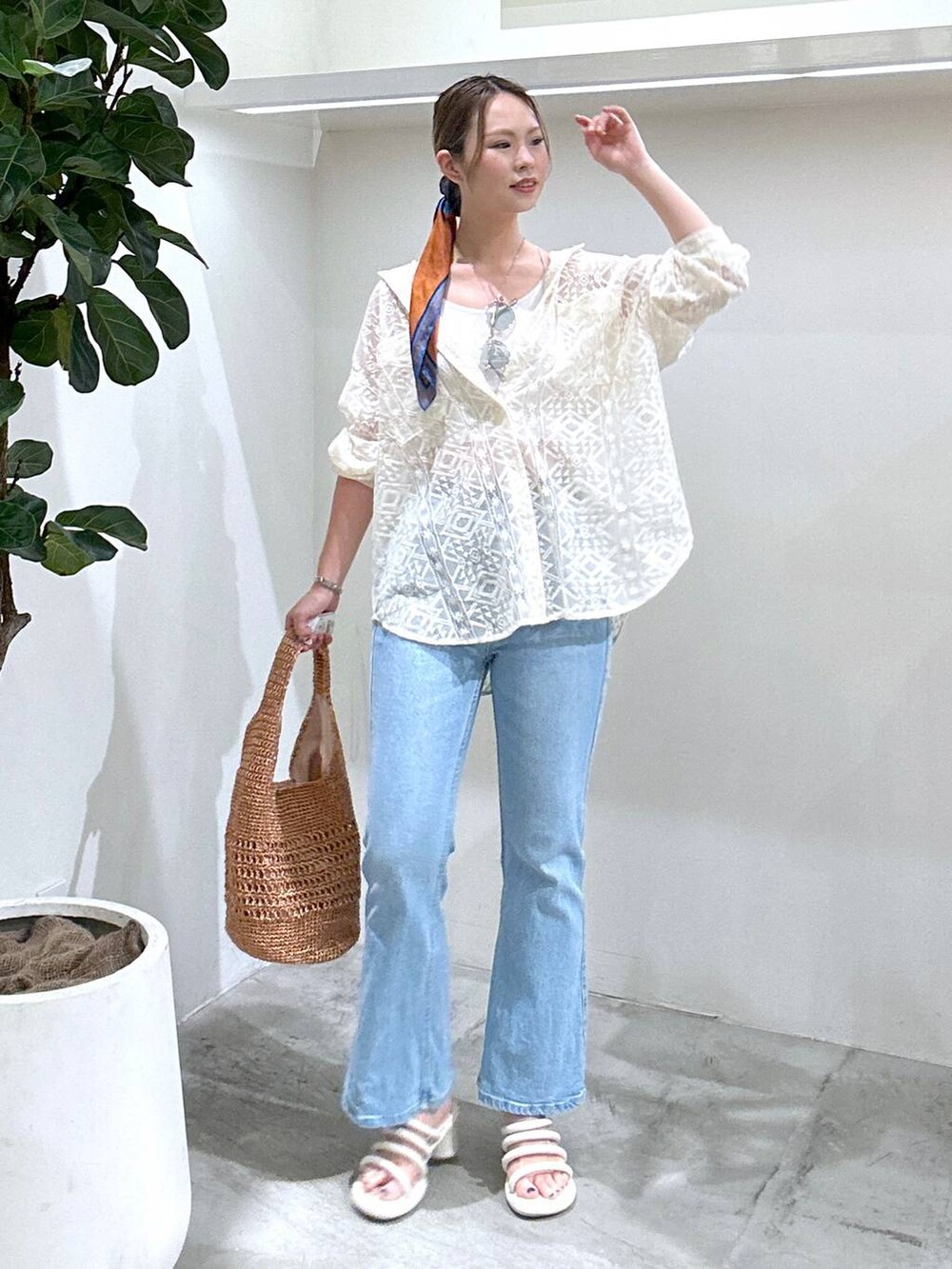 ブルー系のデニムパンツ、ピンク系のハンドバッグ、ホワイト系のシャツ/ブラウスを着用したレディースの春コーディネートの2枚目の写真