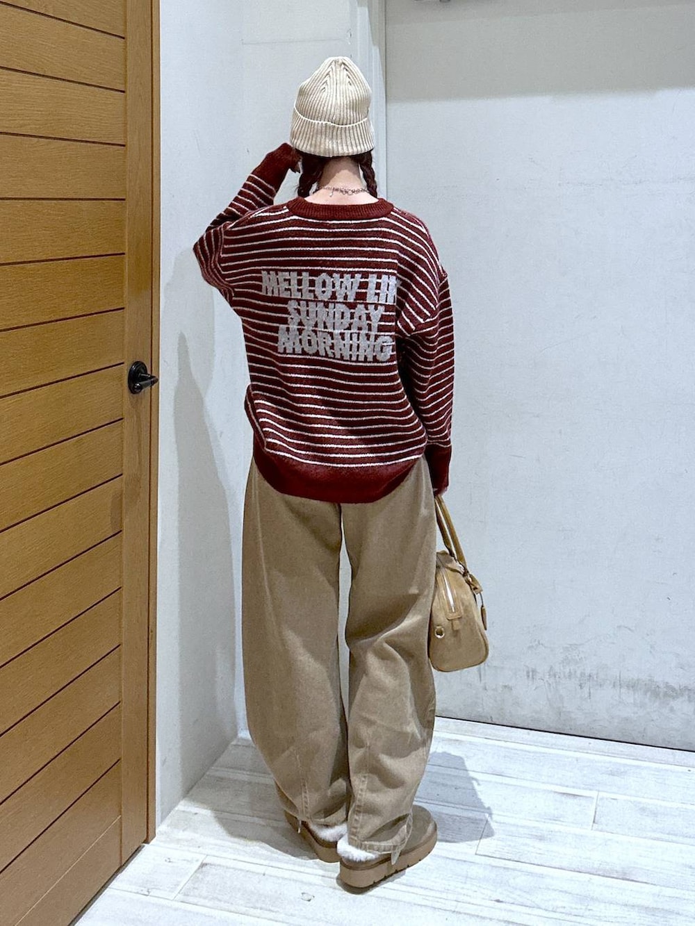 イエロー系のデニムパンツ、ベージュ系のその他シューズ、ベージュ系のハンドバッグを着用したレディースの秋コーディネートの3枚目の写真