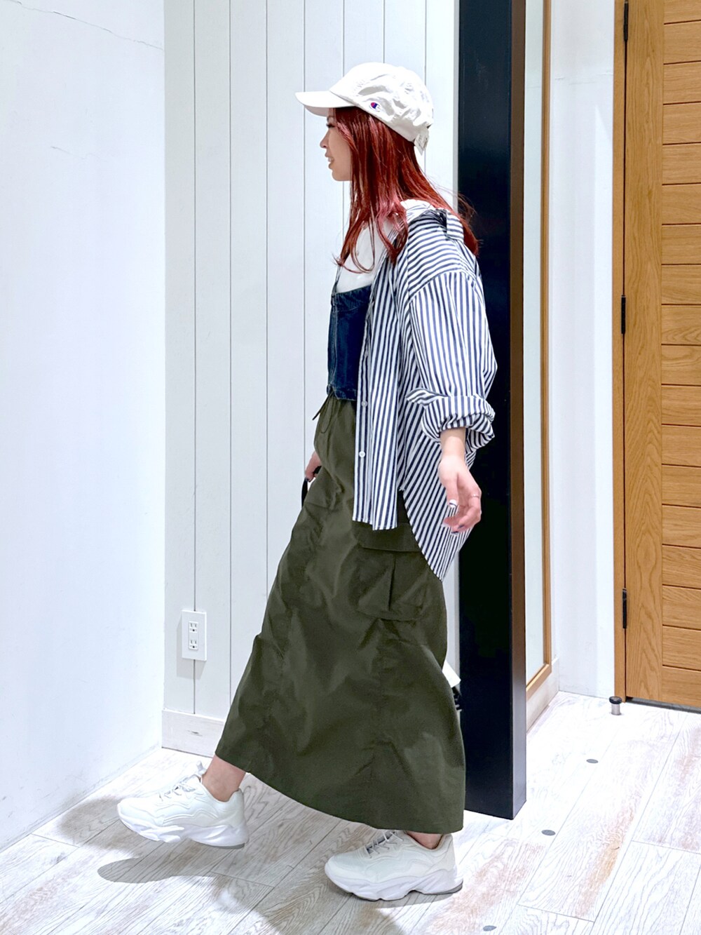 ホワイト系のスニーカー、グリーン系のスカート、ベージュ系のショルダーバッグを着用したレディースの春コーディネートの3枚目の写真