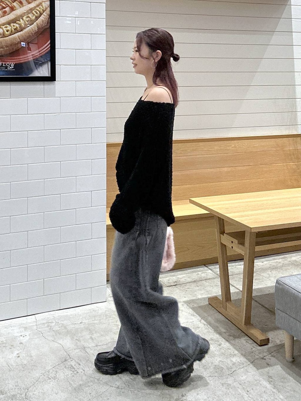 ブラック系のニット/セーター、ブラック系のデニムパンツ、ピンク系のトートバッグを着用したレディースの秋コーディネートの2枚目の写真