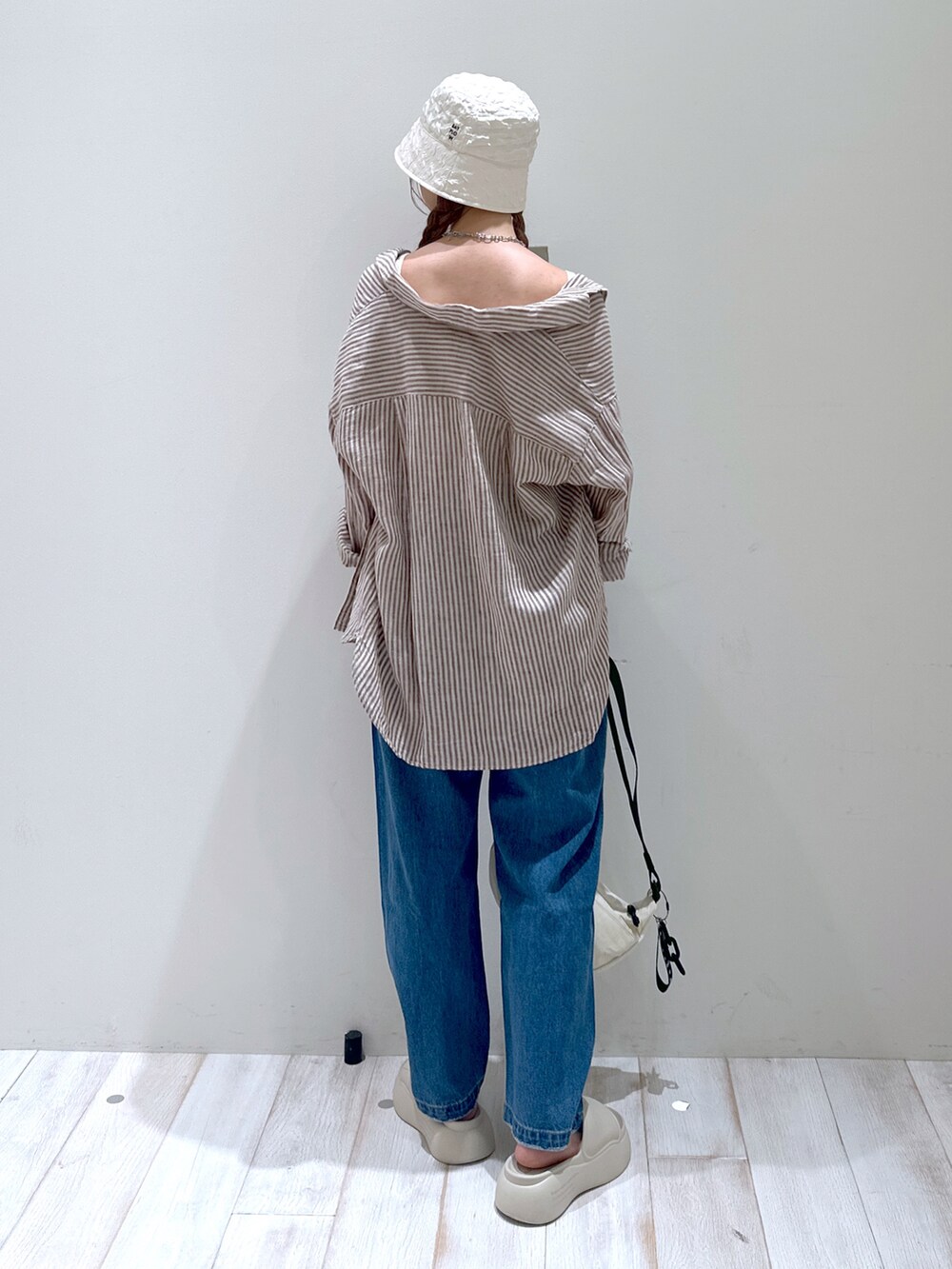 ベージュ系のサンダル、ブラウン系のシャツ/ブラウス、ホワイト系のキャミソールを着用したレディースの秋コーディネートの3枚目の写真