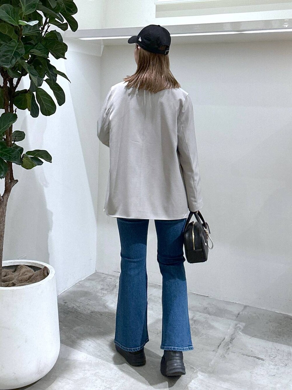 ブラック系のスニーカー、ピンク系のシャツ/ブラウス、ブラック系のショルダーバッグを着用したレディースの春コーディネートの5枚目の写真