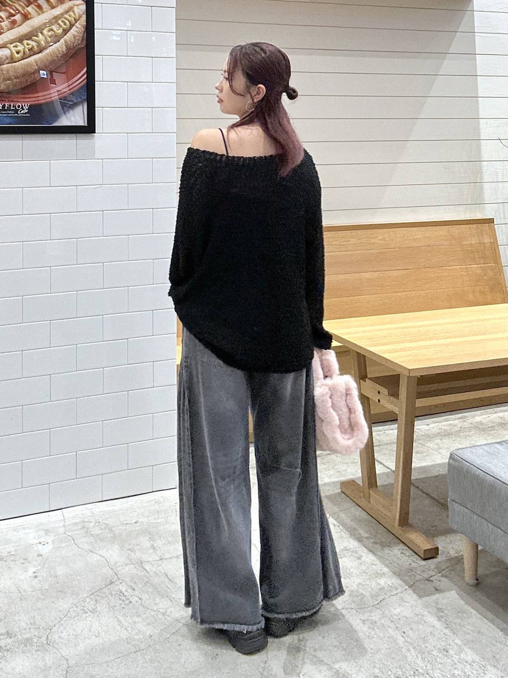 ブラック系のニット/セーター、ブラック系のデニムパンツ、ピンク系のトートバッグを着用したレディースの秋コーディネートの3枚目の写真