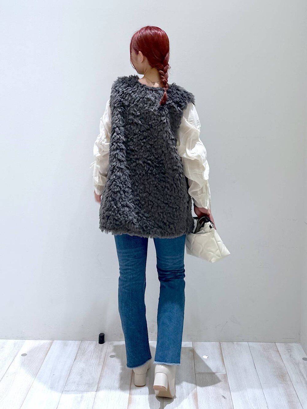 ベージュ系のショルダーバッグ、ホワイト系のシャツ/ブラウス、ブルー系のデニムパンツを着用したレディースの秋コーディネートの3枚目の写真