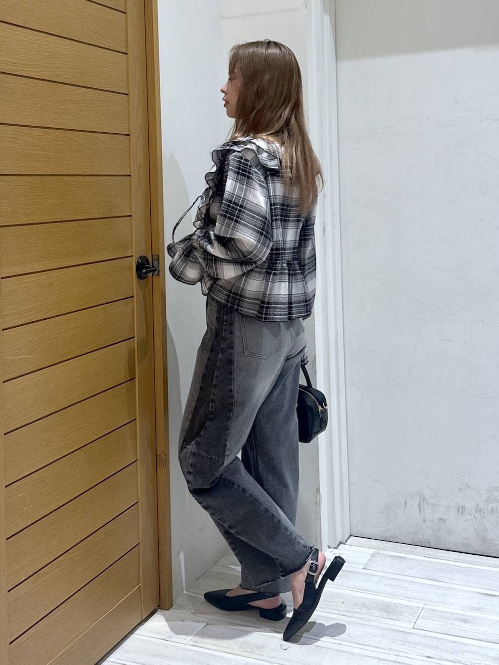 ブラック系のパンプス、ブラック系のデニムパンツ、ブラック系のハンドバッグを着用したレディースの春コーディネートの2枚目の写真