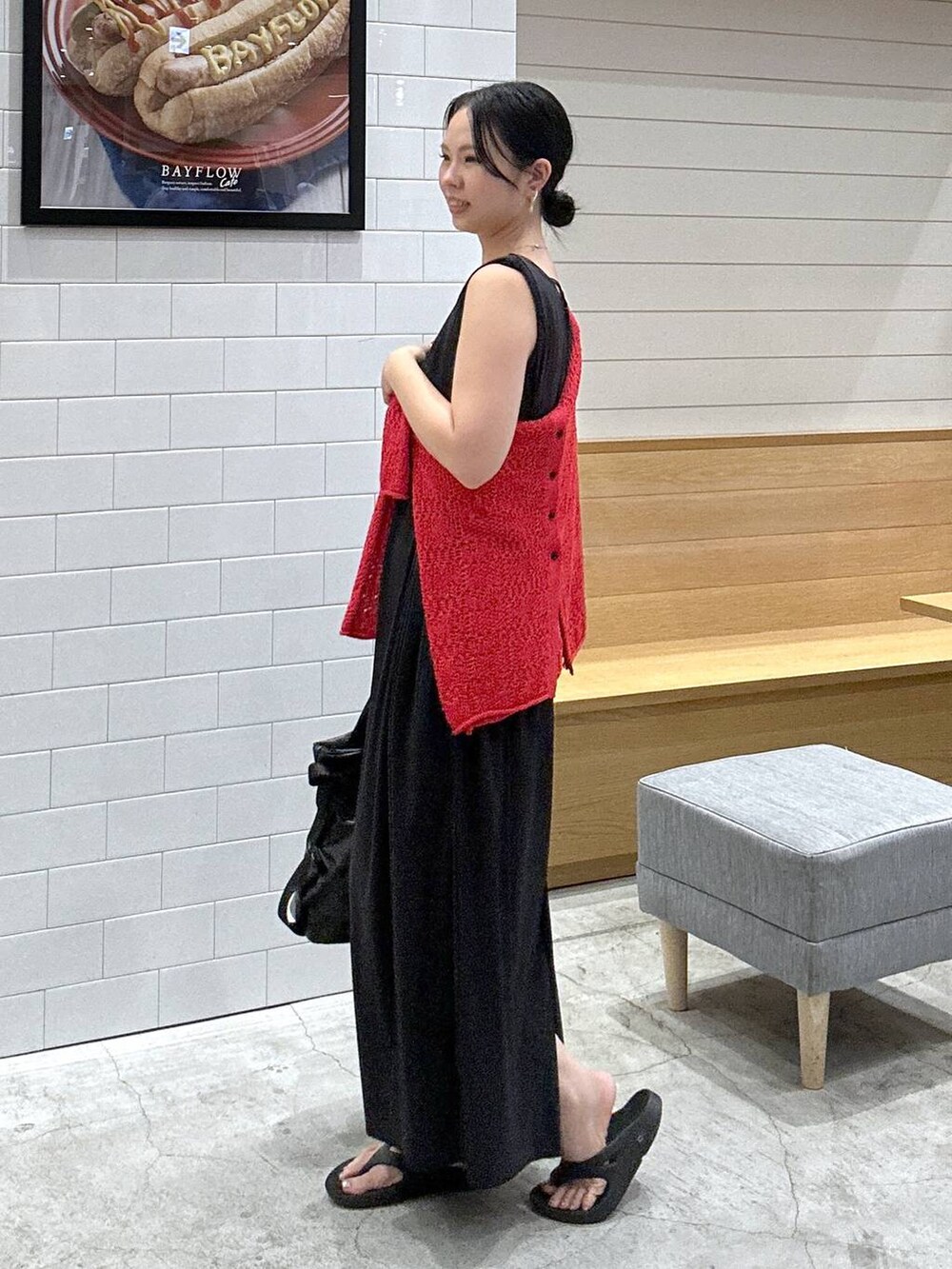 ブラック系のワンピース、ブラック系のトートバッグ、レッド系のカーディガン/ボレロを着用したレディースの夏コーディネートの2枚目の写真