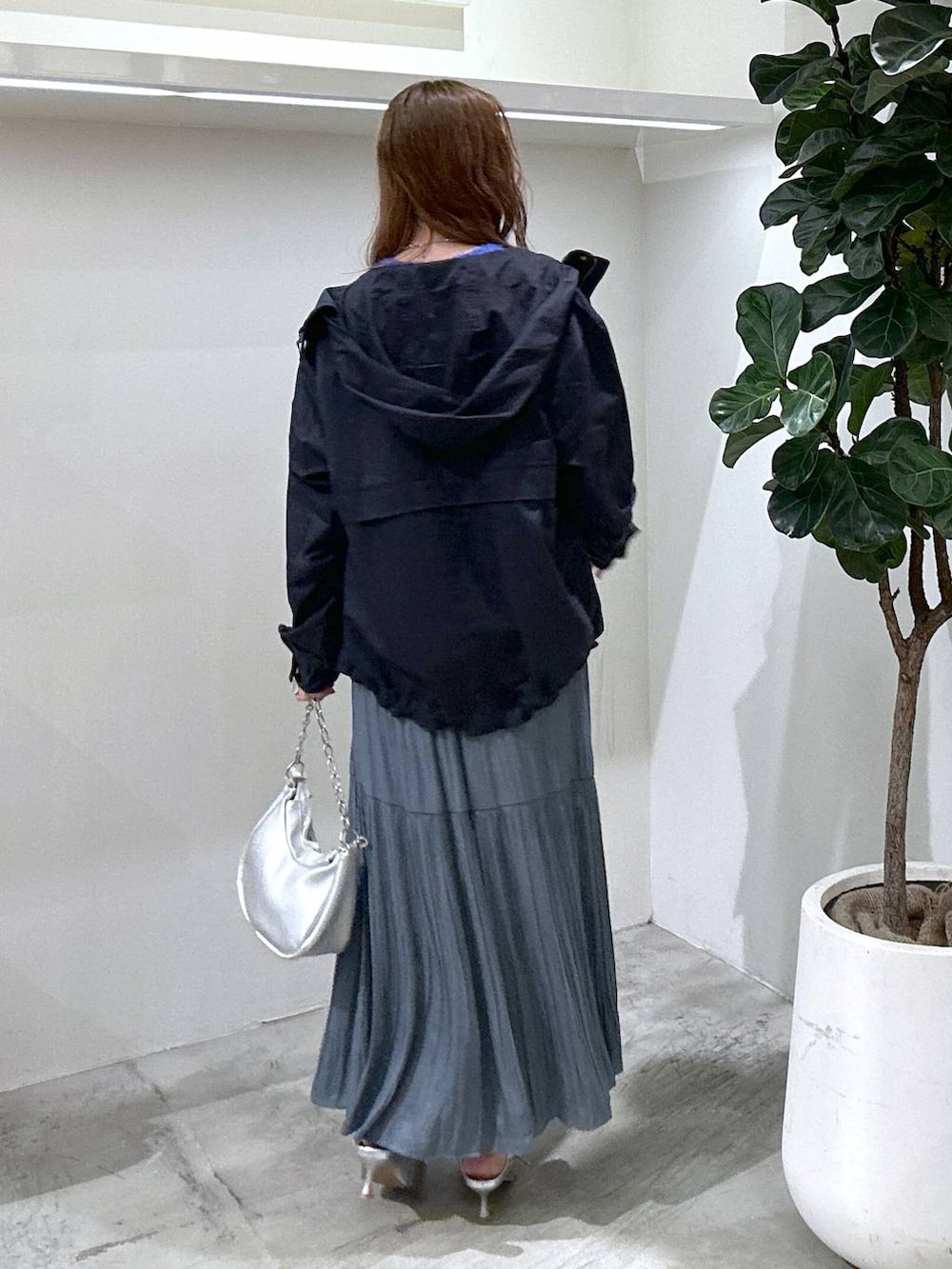 ブルー系のマウンテンパーカー、シルバー系のショルダーバッグ、ブルー系のスカートを着用したレディースの秋コーディネートの4枚目の写真