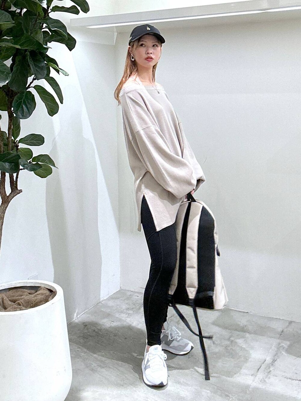 グレー系のスニーカー、ベージュ系のバックパック/リュック、ベージュ系のTシャツ/カットソーを着用したレディースの春コーディネートの2枚目の写真