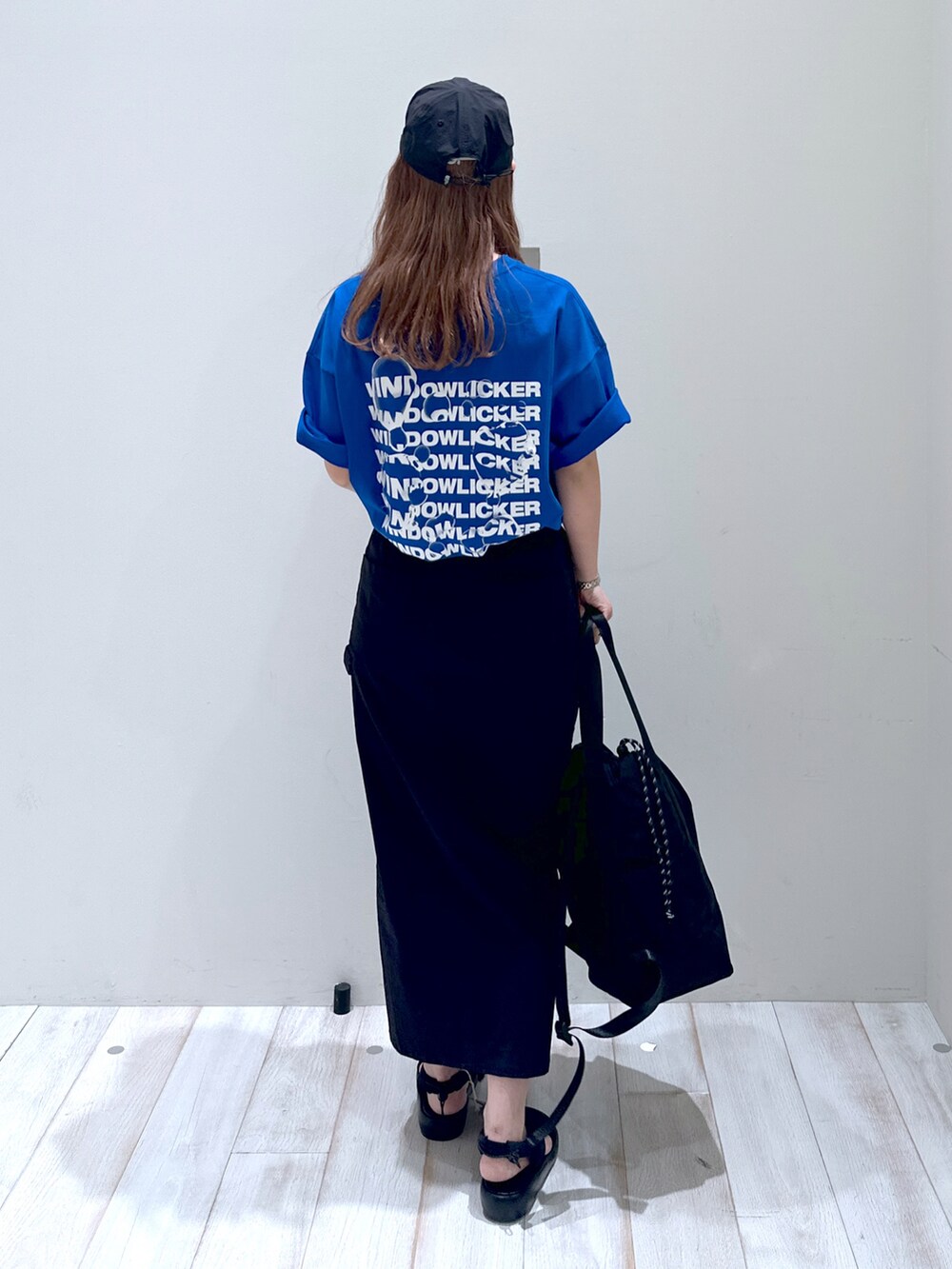 ブラック系のスカート、ブラック系のバックパック/リュック、ブルー系のTシャツ/カットソーを着用したレディースの夏コーディネートの3枚目の写真