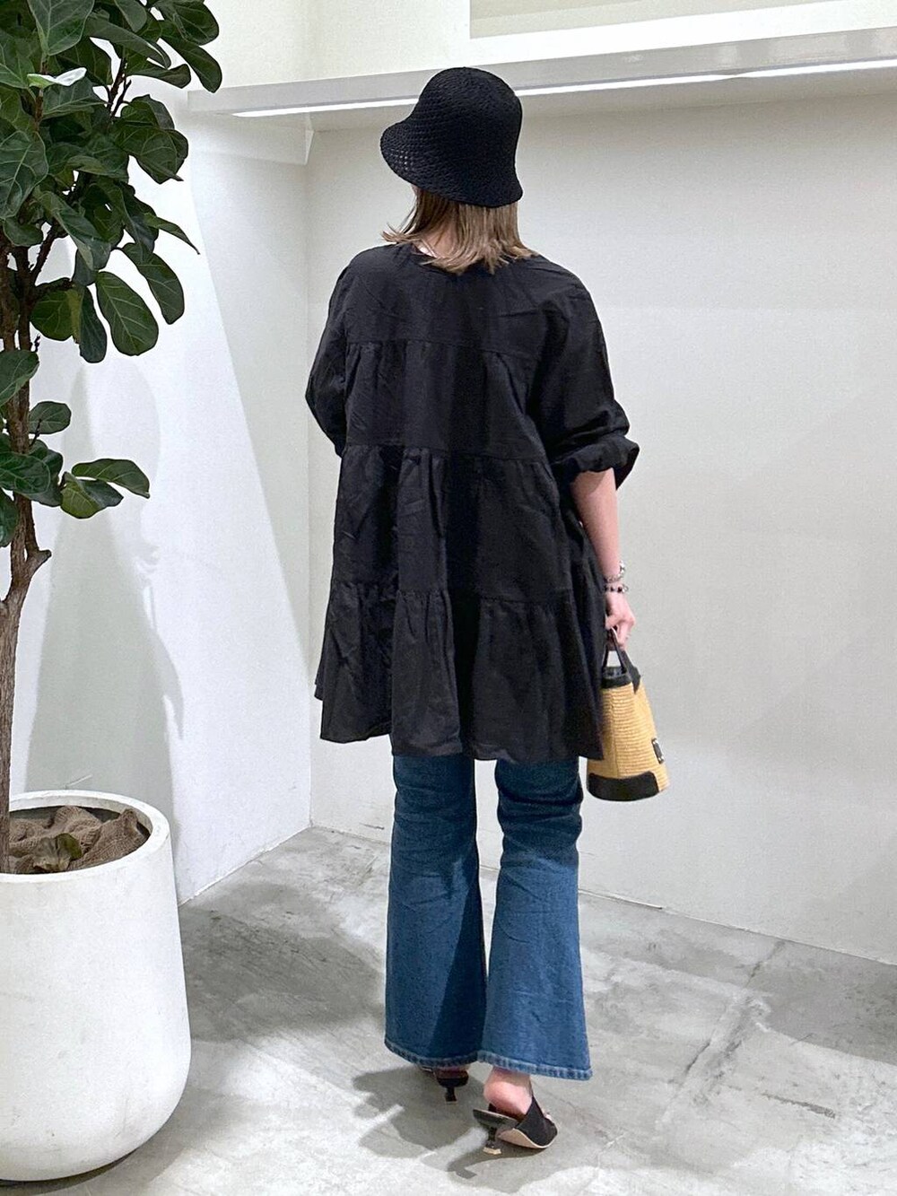 ブラック系のサンダル、ブルー系のデニムパンツ、ブラック系のショルダーバッグを着用したレディースの春コーディネートの3枚目の写真