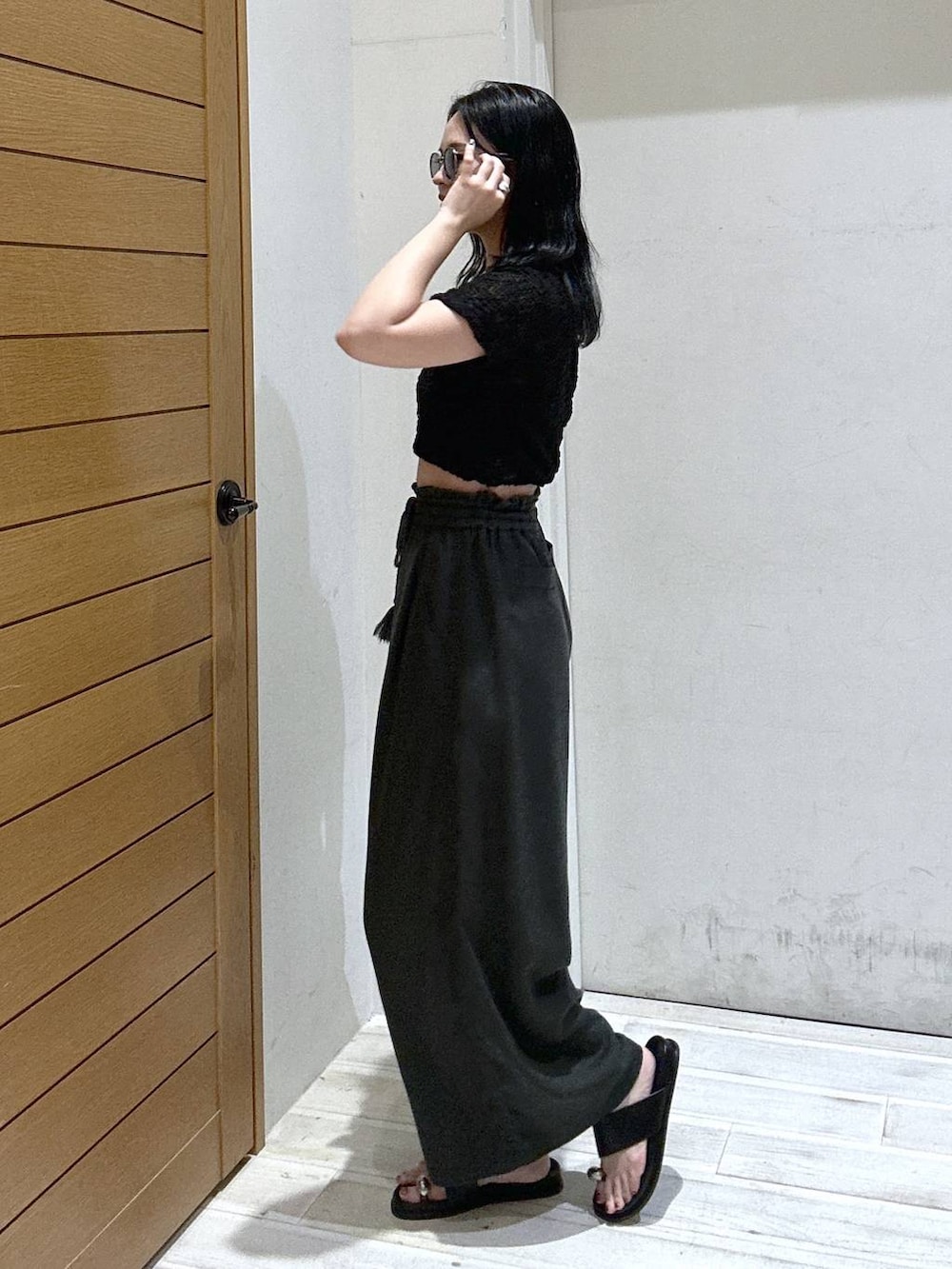 グレー系のその他パンツ、ブラック系のサンダル、ブラック系のTシャツ/カットソーを着用したレディースの夏コーディネートの2枚目の写真
