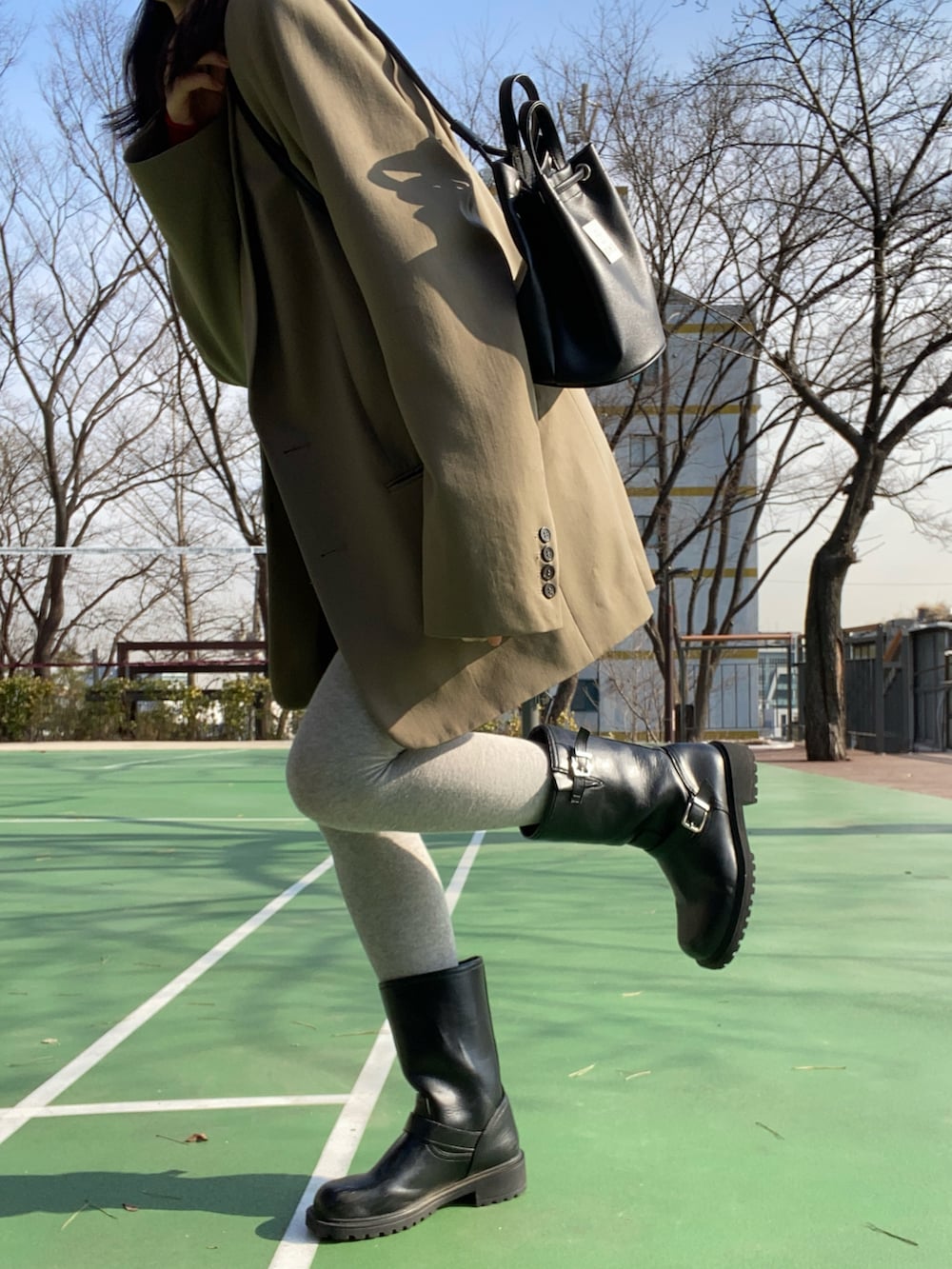 ベージュ系のテーラードジャケット、ホワイト系のその他パンツ、ブラック系のブーツを着用したレディースの冬コーディネートの3枚目の写真