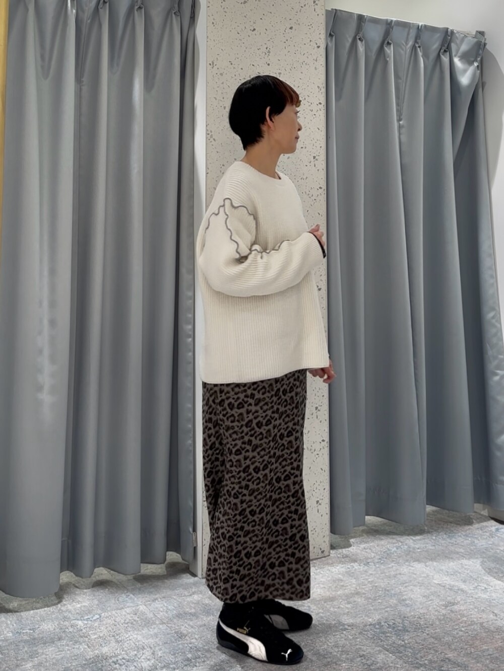 ホワイト系のニット/セーター、グレー系のスカートを着用したレディースの冬コーディネートの2枚目の写真