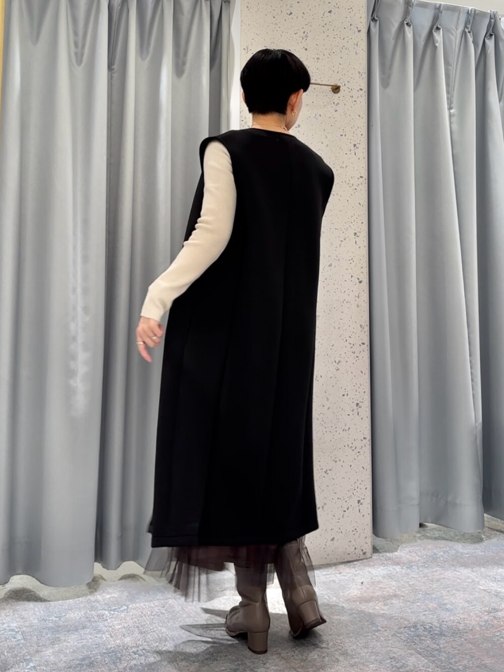 ブラウン系のスカート、ブラック系のその他アウター、ベージュ系のニット/セーターを着用したレディースの冬コーディネートの3枚目の写真