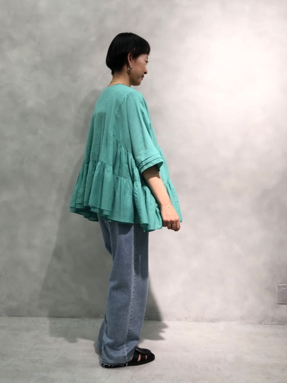 ホワイト系のシャツ/ブラウス、ブラック系のタンクトップ、ブルー系のデニムパンツを着用したレディースの春コーディネートの2枚目の写真