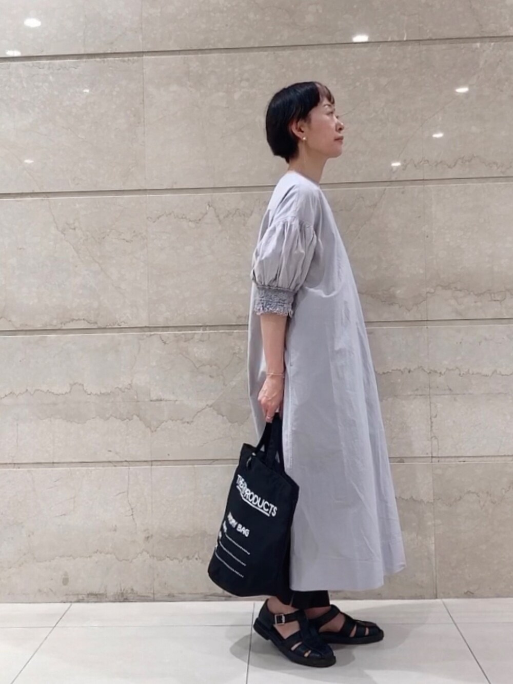 ブルー系のワンピース、ブラック系のトートバッグ、ブラック系のその他パンツを着用したレディースの春コーディネートの2枚目の写真