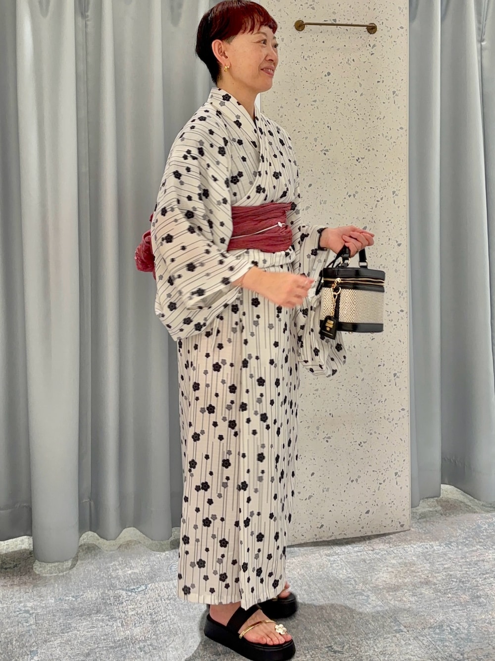 ブラック系のショルダーバッグ、ブラック系のサンダル、ベージュ系の浴衣を着用したレディースの夏コーディネートの2枚目の写真