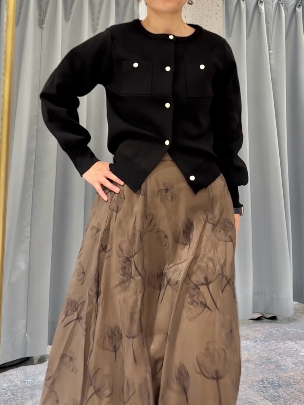 ブラック系のカーディガン/ボレロ、ブラック系のブーツ、イエロー系のスカートを着用したレディースの秋コーディネートの2枚目の写真