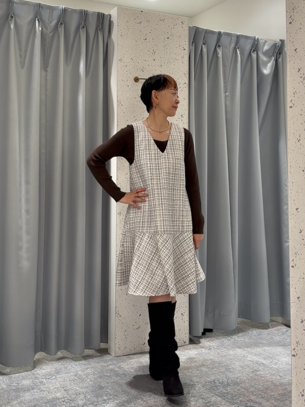 ホワイト系のチェスターコート、ブラウン系のニット/セーター、ブラック系のブーツを着用したレディースの秋コーディネートの4枚目の写真