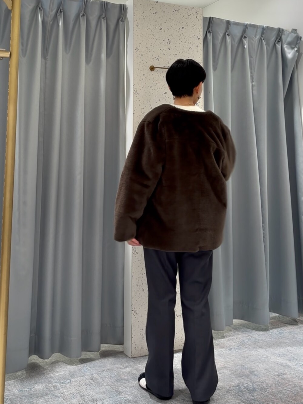 グレー系のスラックス、ホワイト系のニット/セーター、ブラウン系のノーカラーコートを着用したレディースの冬コーディネートの4枚目の写真