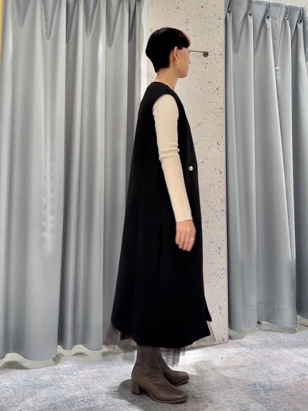 ブラウン系のスカート、ブラック系のその他アウター、ベージュ系のニット/セーターを着用したレディースの冬コーディネートの2枚目の写真