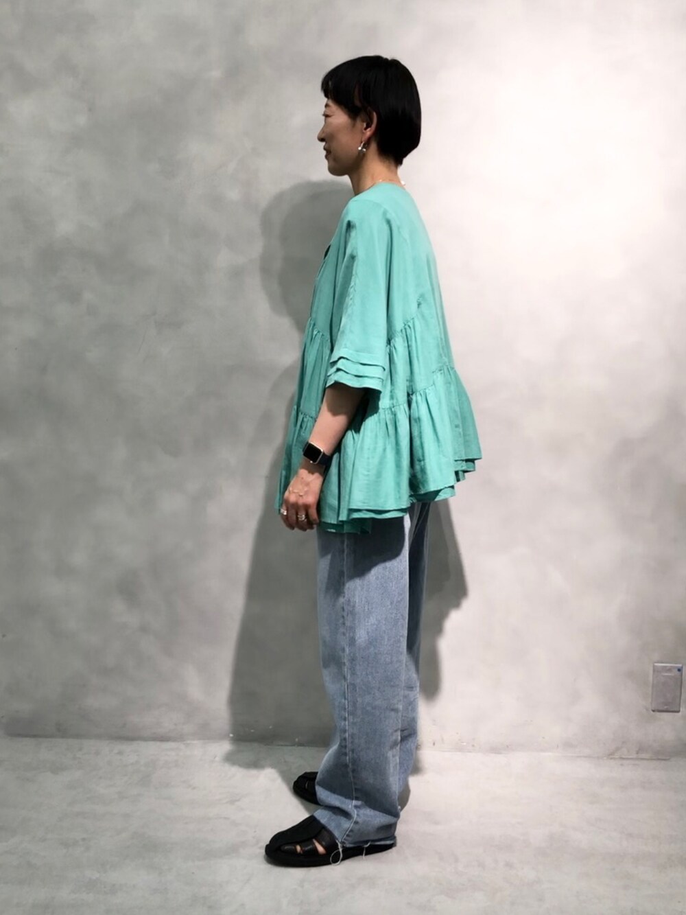 ホワイト系のシャツ/ブラウス、ブラック系のタンクトップ、ブルー系のデニムパンツを着用したレディースの春コーディネートの3枚目の写真