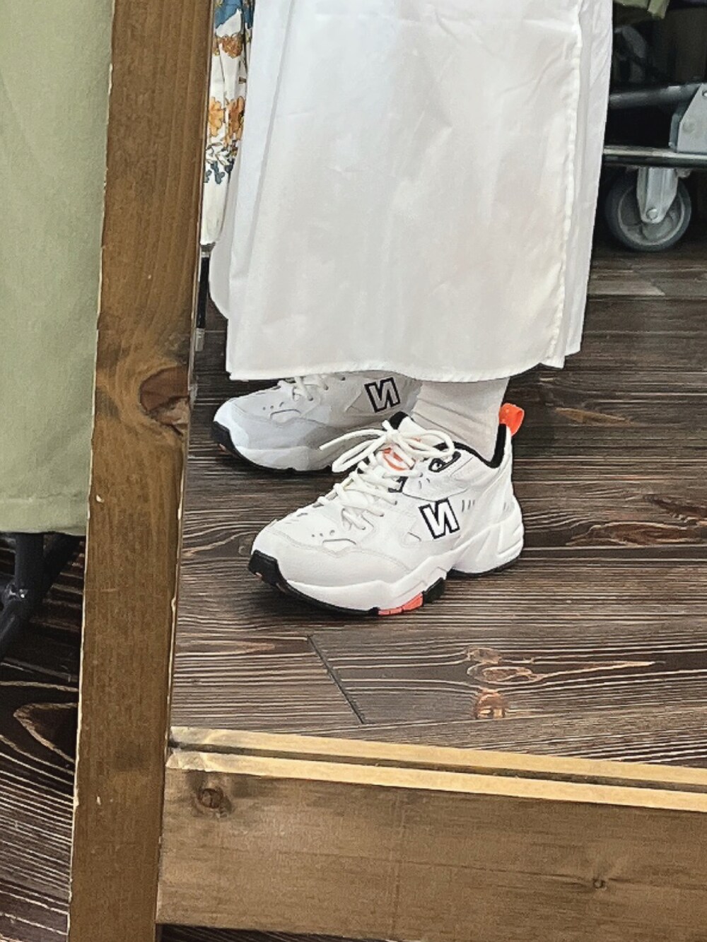 ベージュ系のワンピース、ホワイト系のベスト、グリーン系のトップスを着用したレディースの春コーディネートの2枚目の写真