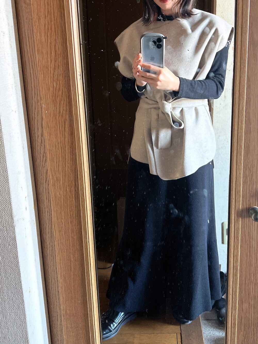 ホワイト系のベスト、ブラック系のワンピース、ブラック系のTシャツ/カットソーを着用したレディースの冬コーディネートの3枚目の写真