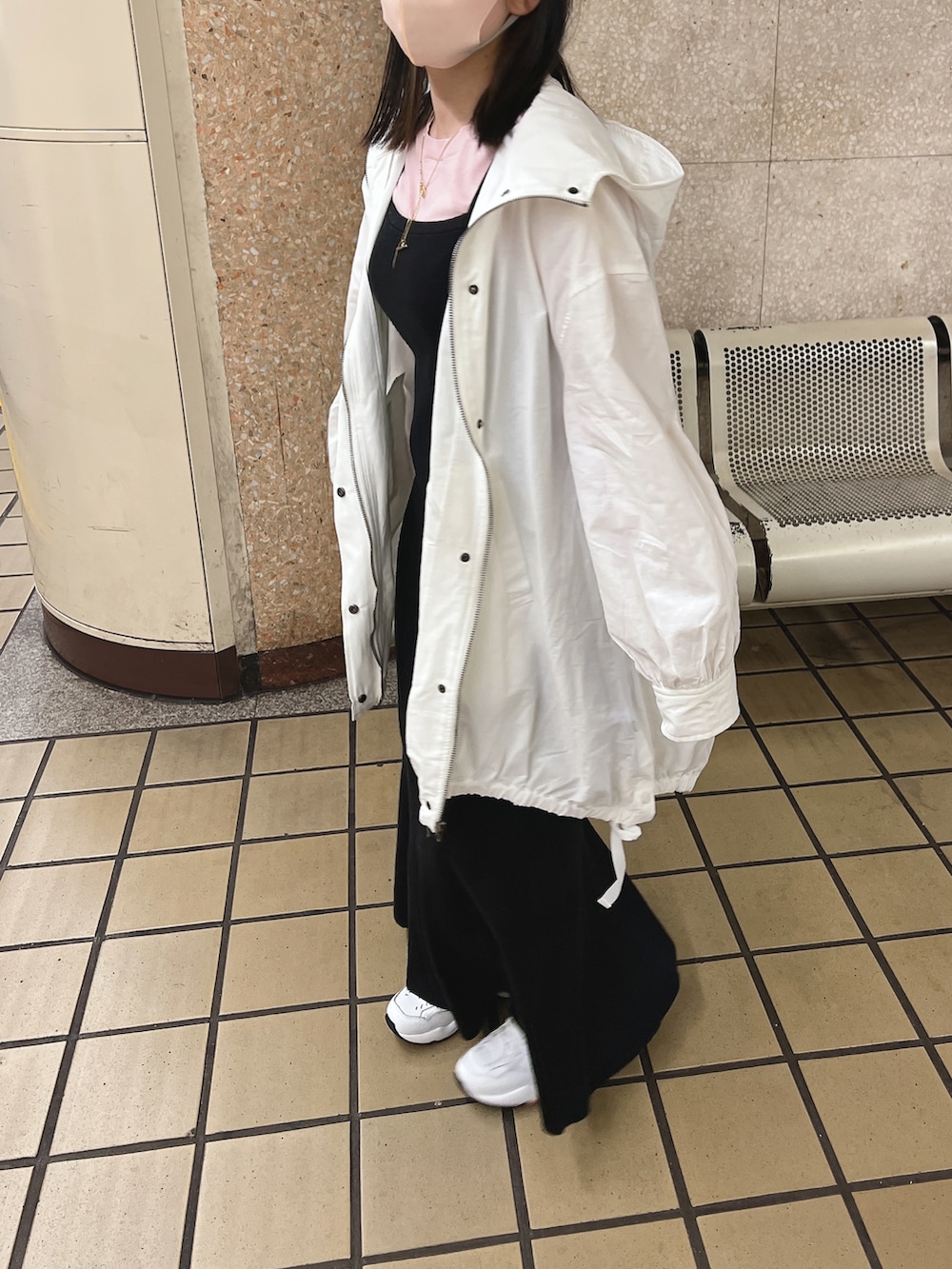 ブラック系のワンピース、ホワイト系のマウンテンパーカー、ピンク系のニット/セーターを着用したレディースの春コーディネートの2枚目の写真