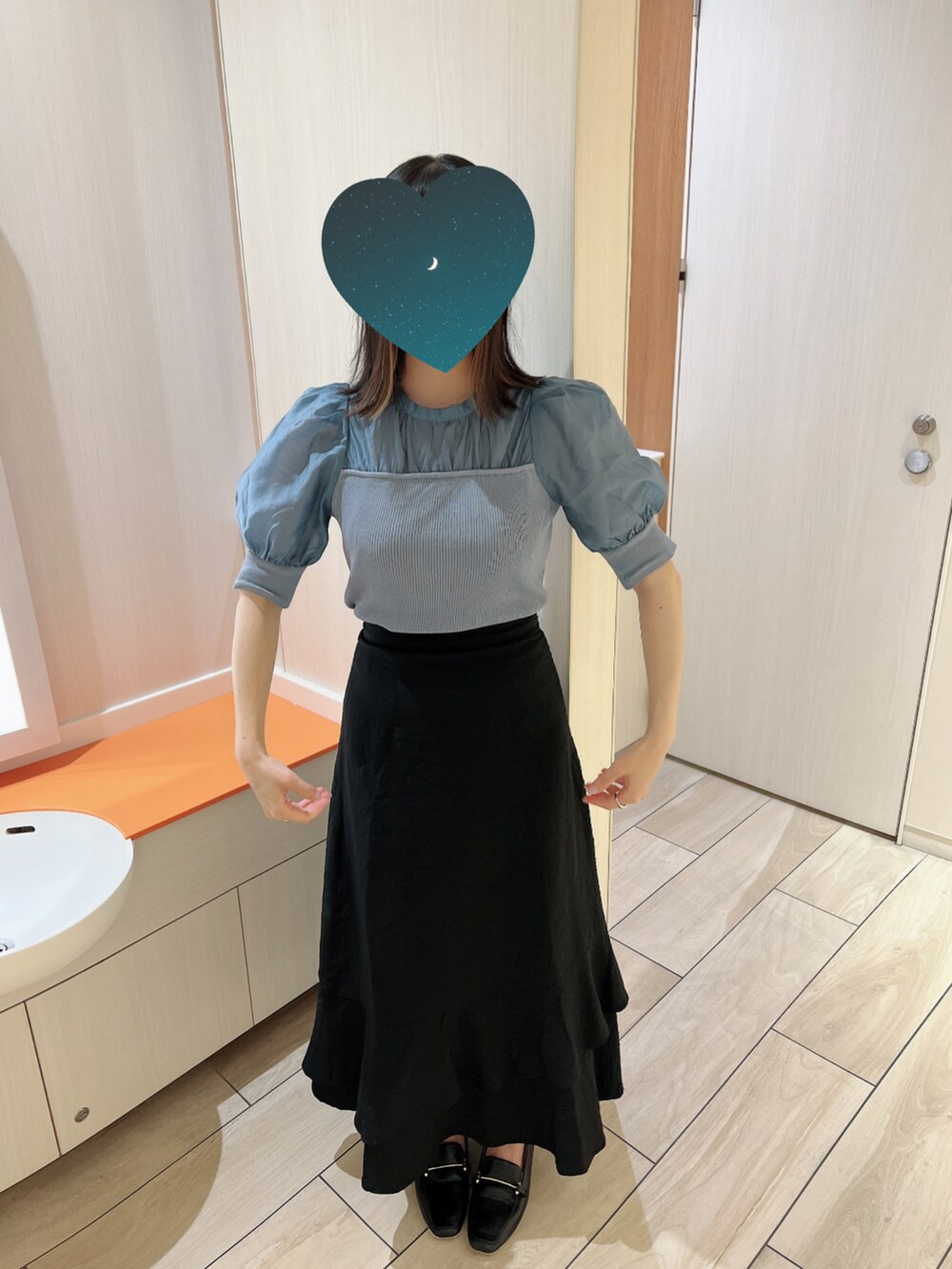 ブルー系のニット/セーター、ブラック系のスカートを着用したレディースの夏コーディネートの2枚目の写真