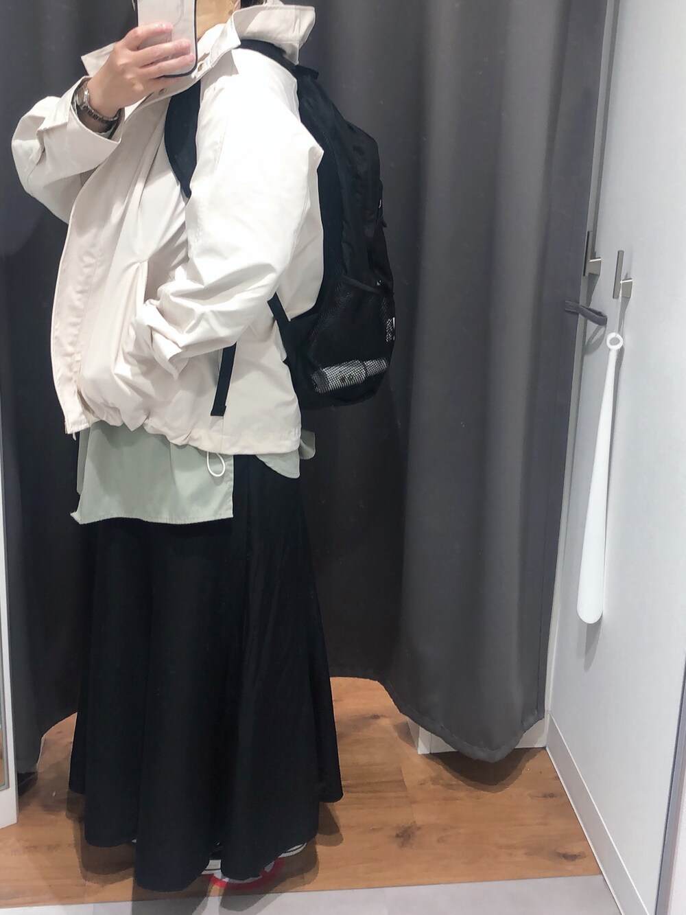 グリーン系のシャツ/ブラウス、ホワイト系のマウンテンパーカー、ブラック系のスカートを着用したレディースの春コーディネートの2枚目の写真