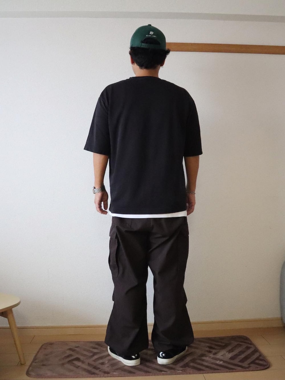 ホワイト系のTシャツ/カットソー、ブラウン系のカーゴパンツ、ブラック系のスニーカーを着用したメンズの夏コーディネートの3枚目の写真