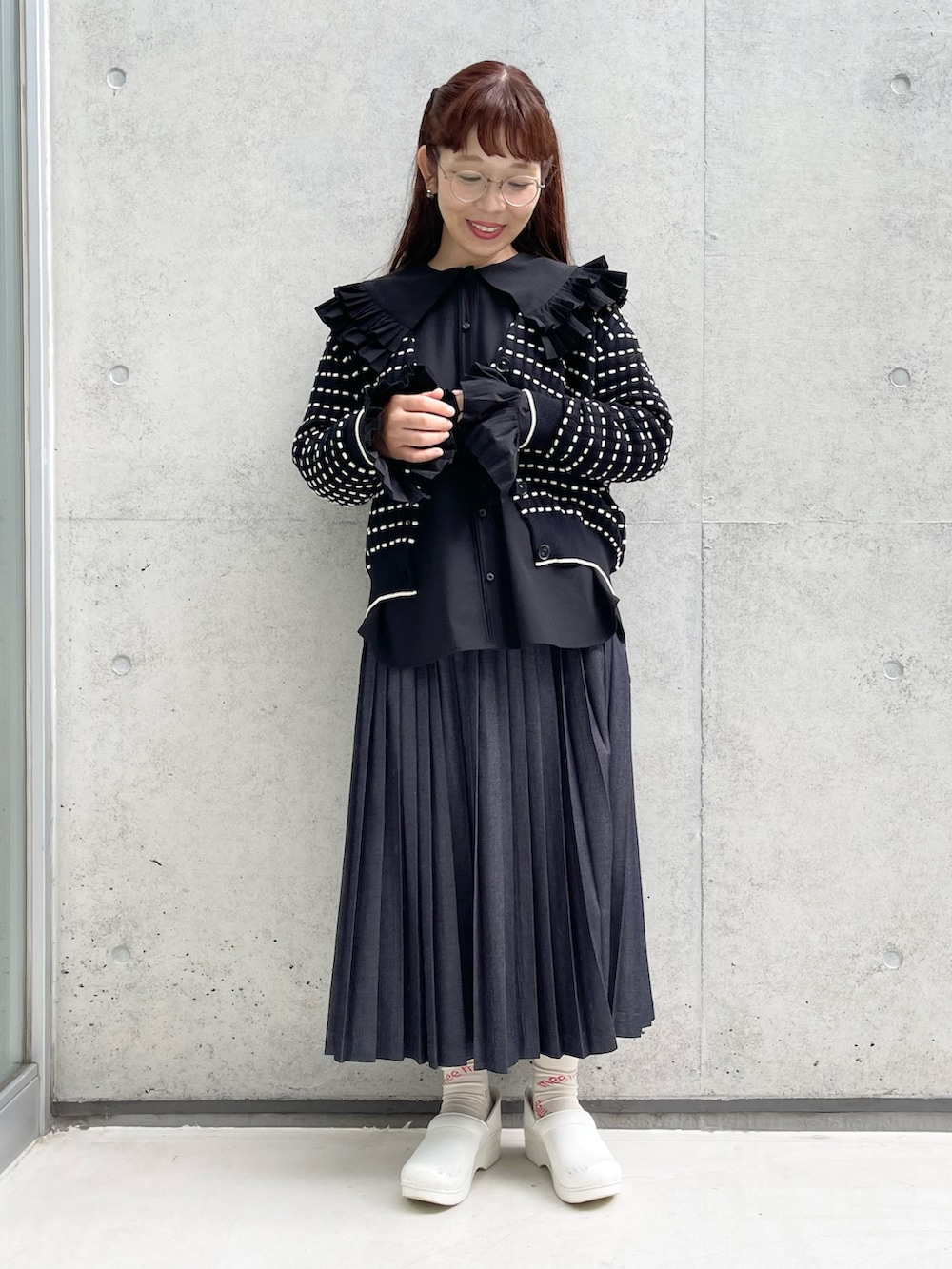 ブルー系のデニムスカート、ブラック系のシャツ/ブラウス、ホワイト系のサンダルを着用したレディースの秋コーディネートの2枚目の写真