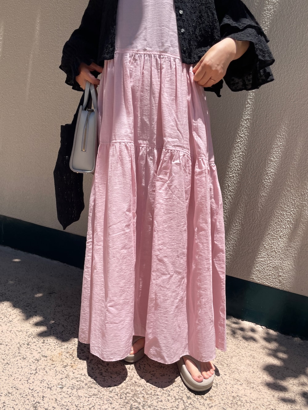 ブラック系のシャツ/ブラウス、ブラック系のトートバッグ、ベージュ系のサンダルを着用したレディースの夏コーディネートの4枚目の写真