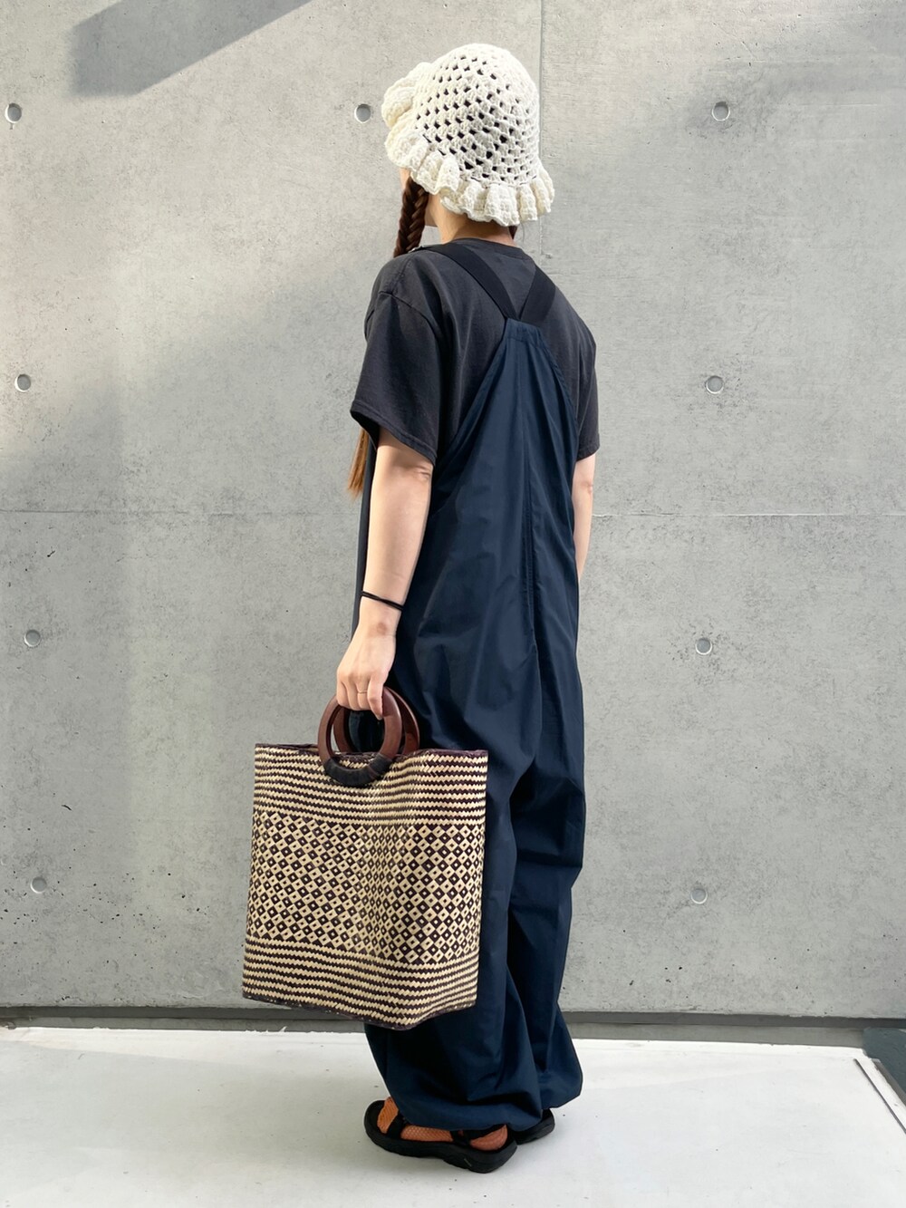 ブルー系のサロペット/オーバーオール、ブラック系のTシャツ/カットソー、ブラック系のサンダルを着用したレディースの夏コーディネートの3枚目の写真