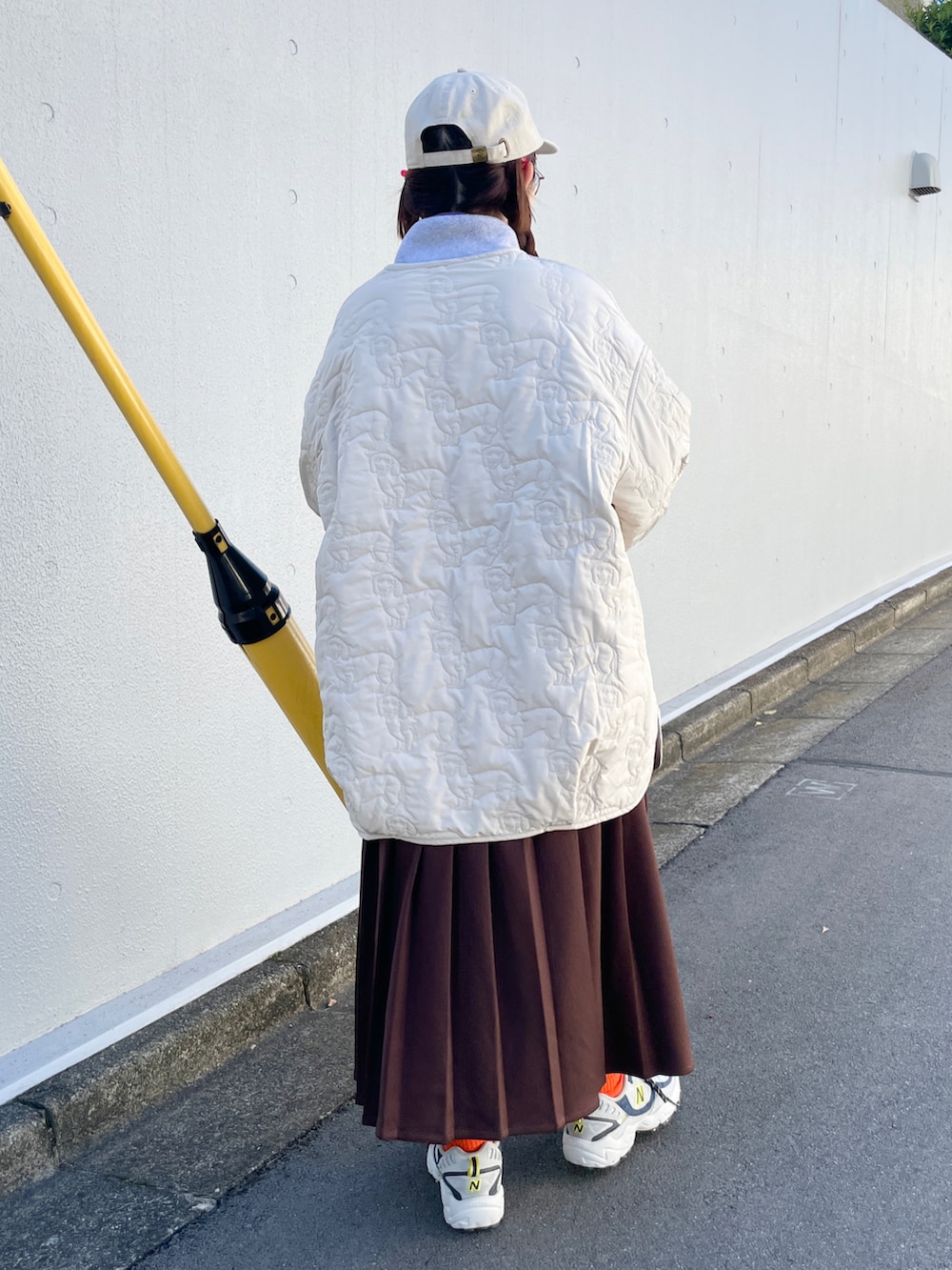 ベージュ系のノーカラージャケット、ブラウン系のスカート、ベージュ系のキャップを着用したレディースの秋コーディネートの4枚目の写真