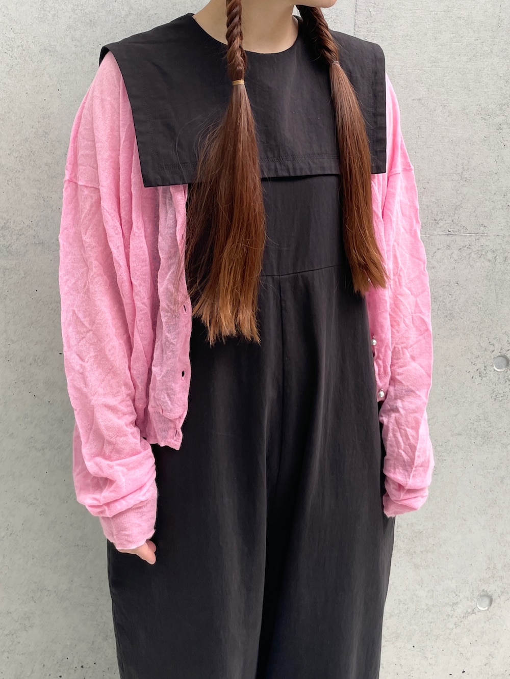 ブラック系のつなぎ/オールインワン、ピンク系のニット/セーターを着用したレディースの夏コーディネートの2枚目の写真