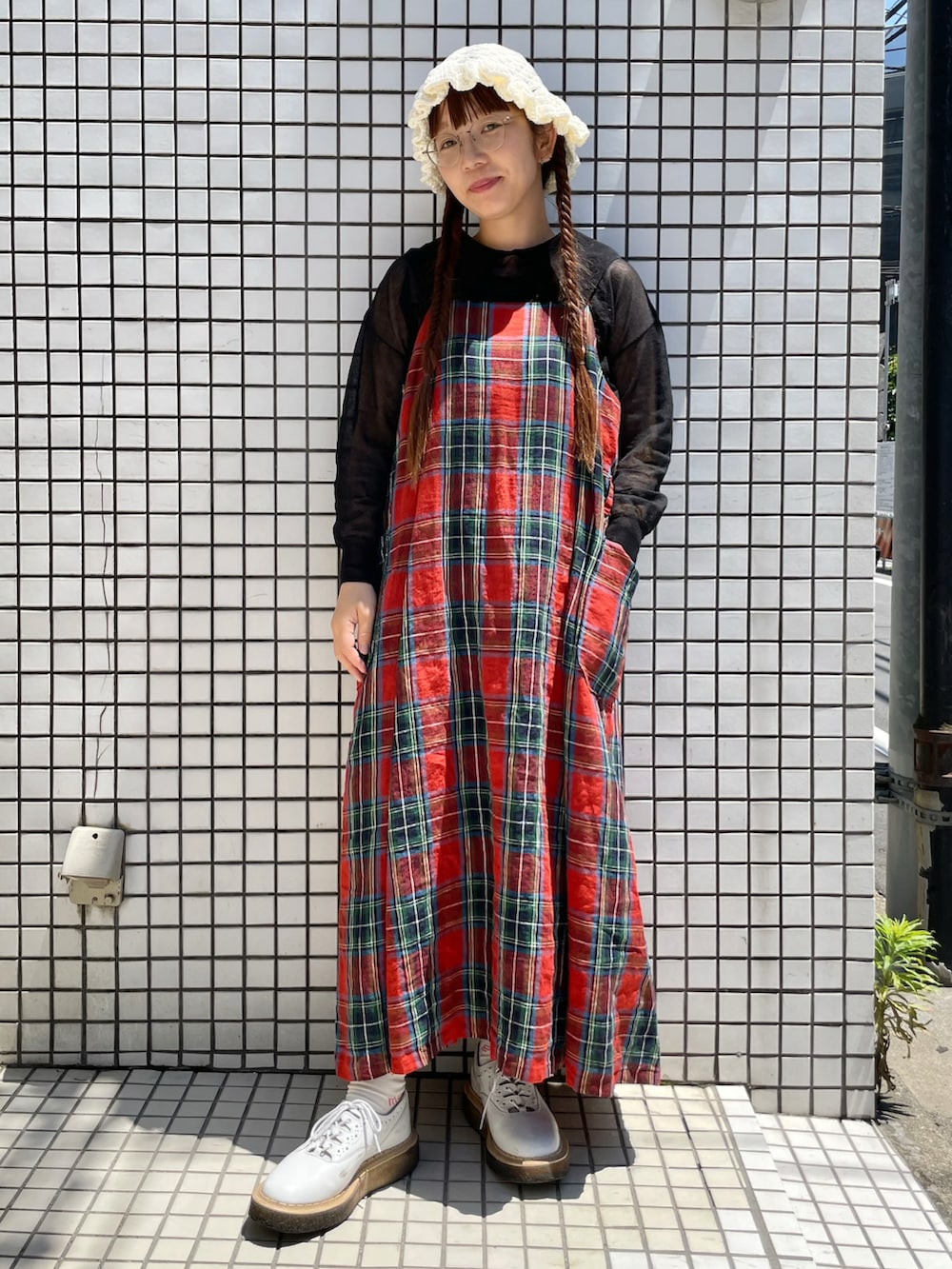 レッド系のワンピース、ブラック系のニット/セーター、ホワイト系のソックス/靴下を着用したレディースの春コーディネートの2枚目の写真