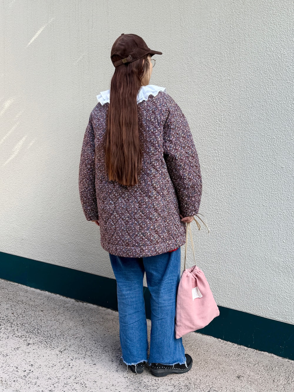 レッド系のその他アウター、ピンク系のトートバッグ、ブラウン系のキャップを着用したレディースの秋コーディネートの2枚目の写真