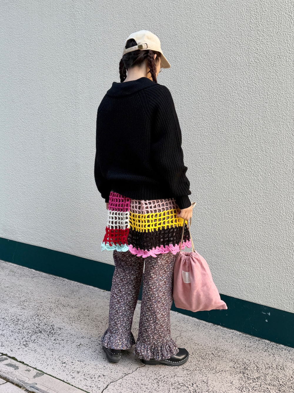 ブラック系のニット/セーター、レッド系のその他パンツ、ピンク系のトートバッグを着用したレディースの秋コーディネートの2枚目の写真