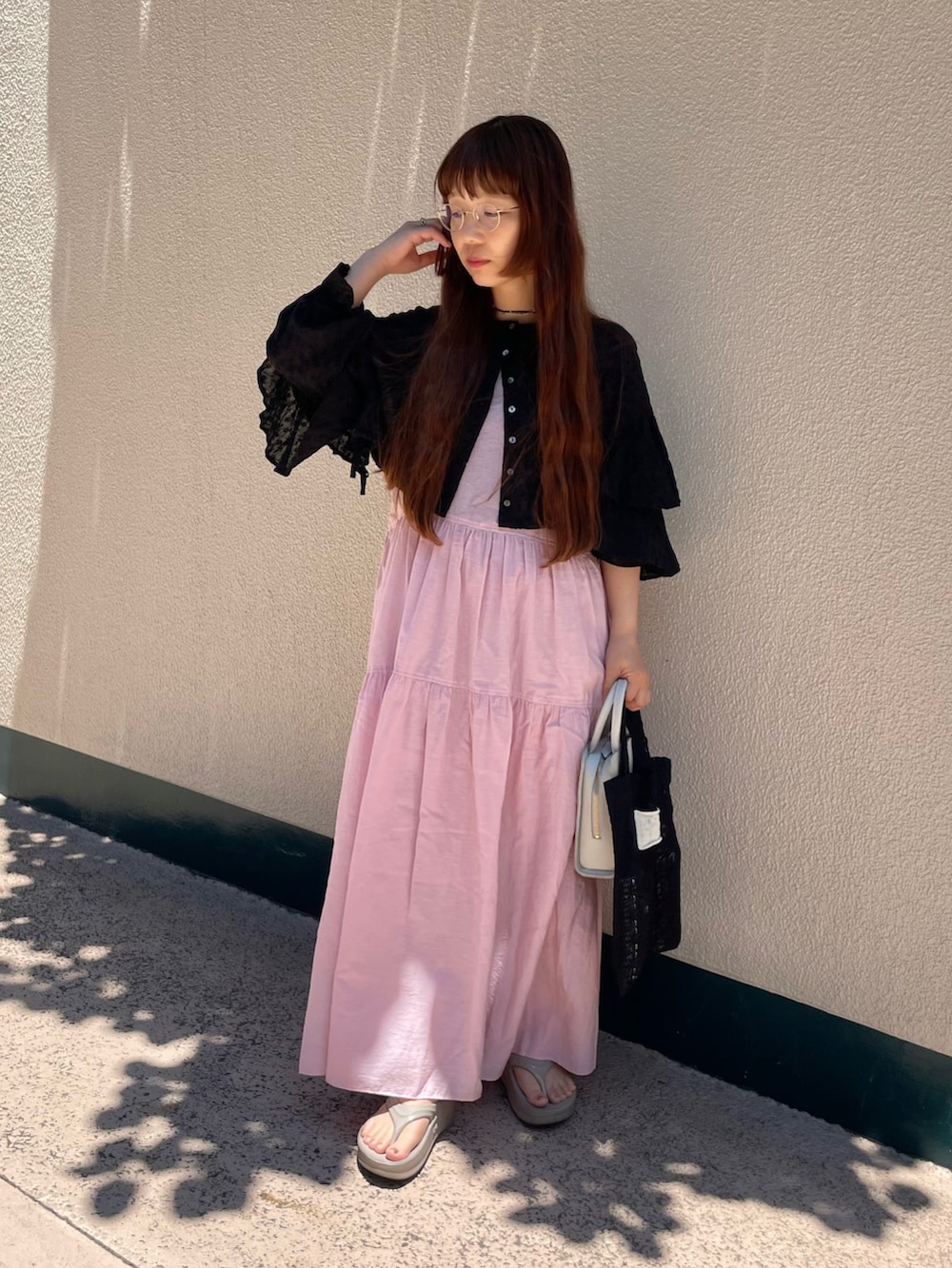 ブラック系のシャツ/ブラウス、ブラック系のトートバッグ、ベージュ系のサンダルを着用したレディースの夏コーディネートの2枚目の写真