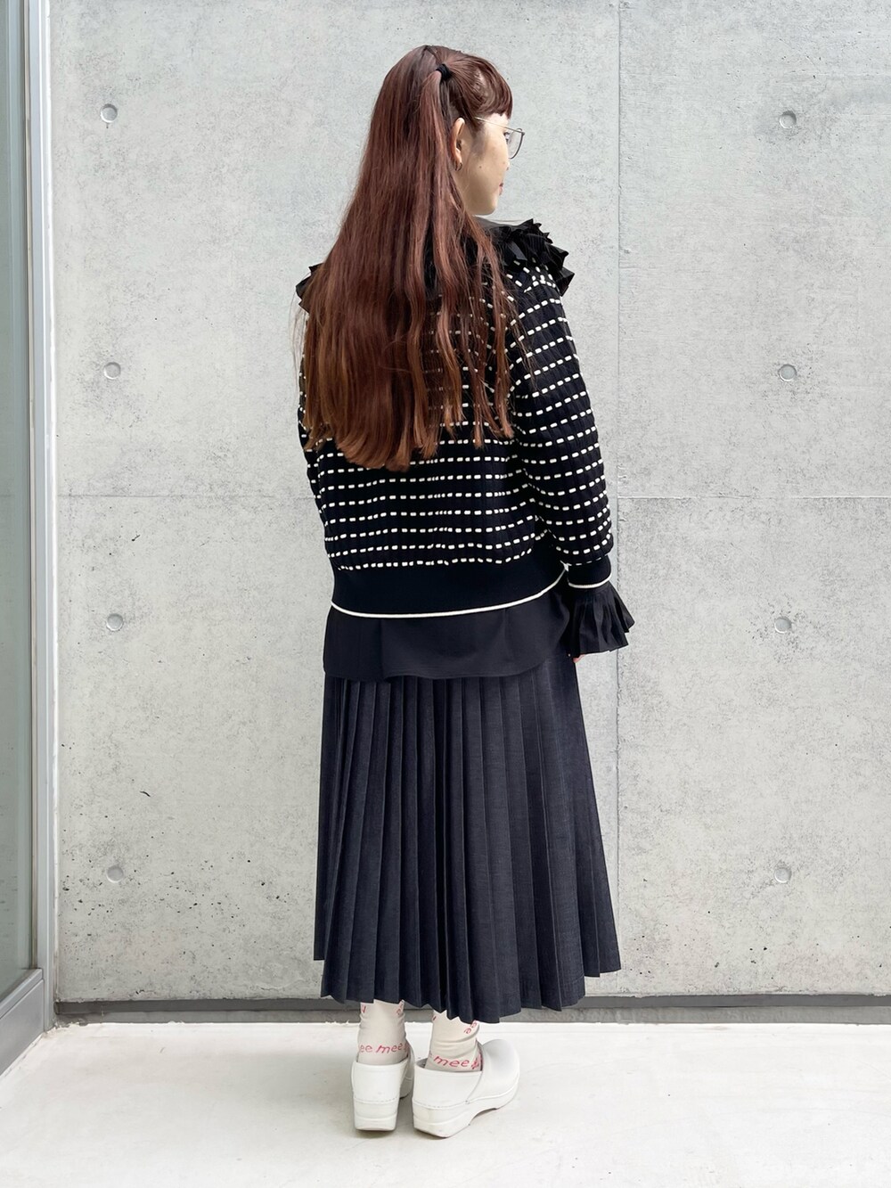 ブルー系のデニムスカート、ブラック系のシャツ/ブラウス、ホワイト系のサンダルを着用したレディースの秋コーディネートの3枚目の写真